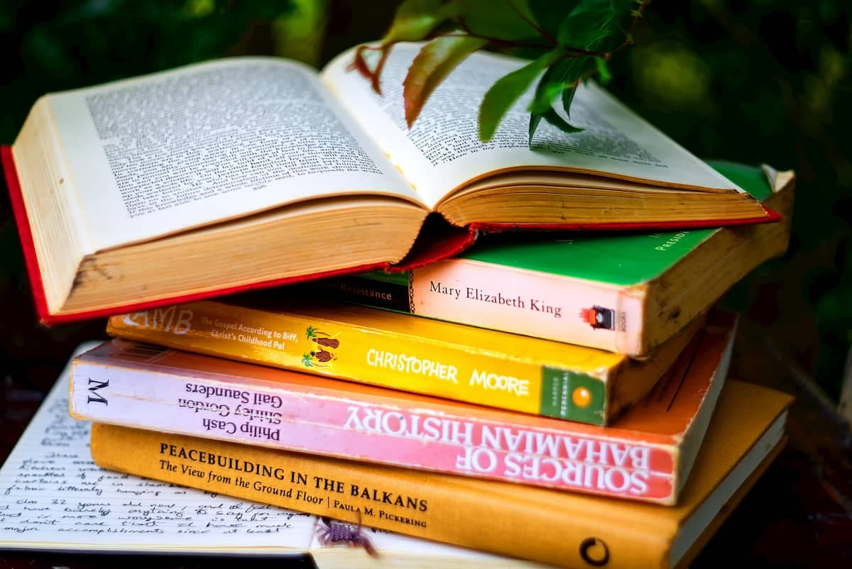 تصویری از چندین کتاب انگلیسی روی هم که یکی از آن‌ها باز است