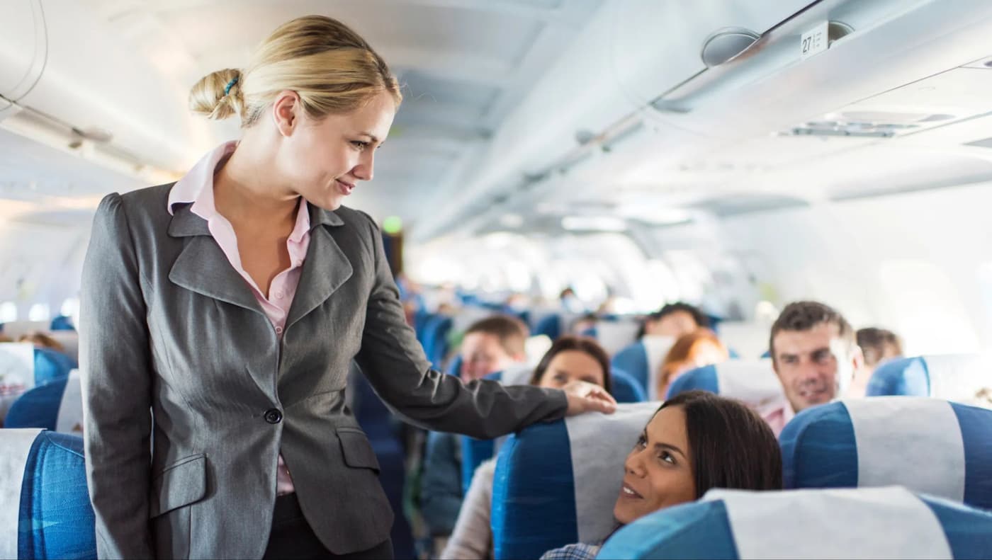 مهماندار خانم که با یک مسافر زن در هوپیما صحبت میکند