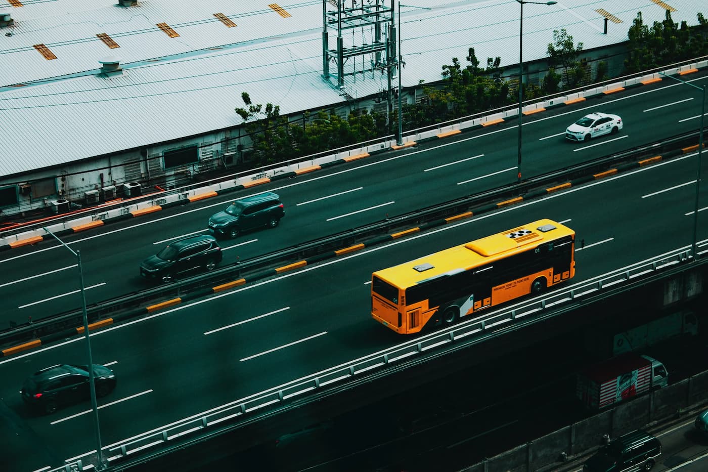 تصویری از اتوبوسی زرد و نارنجی‌رنگ در یک اتوبان